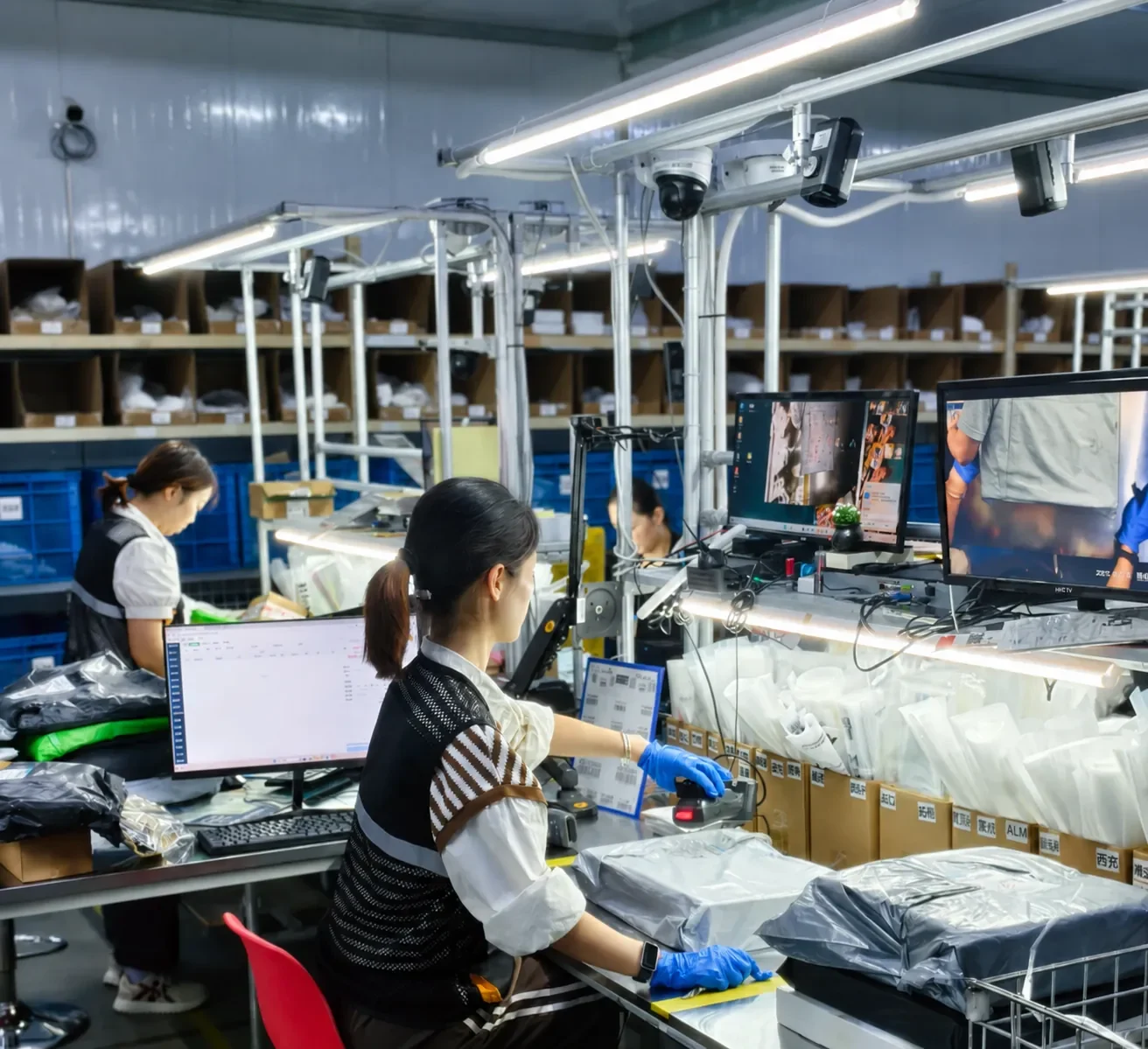 Library photograph of staff handling goods at a warehouse inspection workstation.